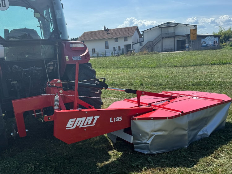 Bild von einem EMAT Trommelmähwerk das von einem Traktor gezogn wird.