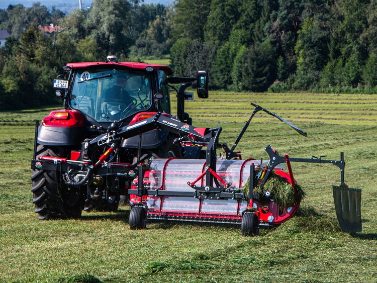 Case IH Vestrum mit einem Heckschwader von BB Umwelttechnik im Grünland