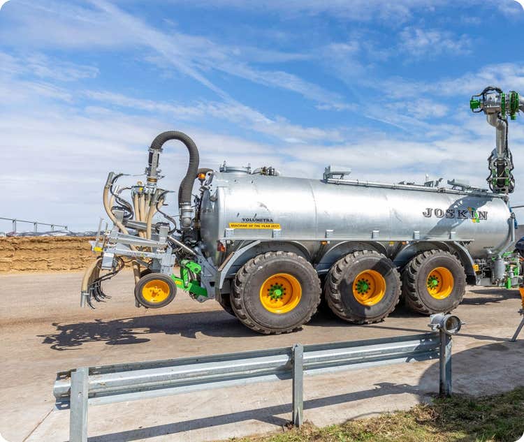 Volumentra Güllefass steht auf einem Hof vor einem Silo