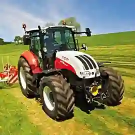 Weiß-roter Steyr Traktor auf grünem Feld