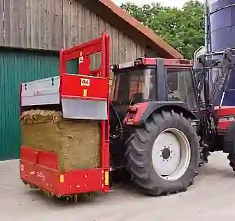 Bild eines roten Siloblockschneiders an einem Traktor befestigt