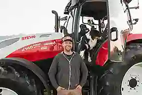 Bild eines Kunden vor einem Steyr Traktor